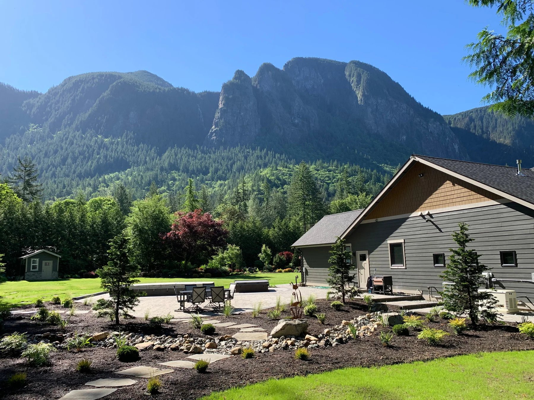 Mount Si rises beyond the home and newly planted garden.