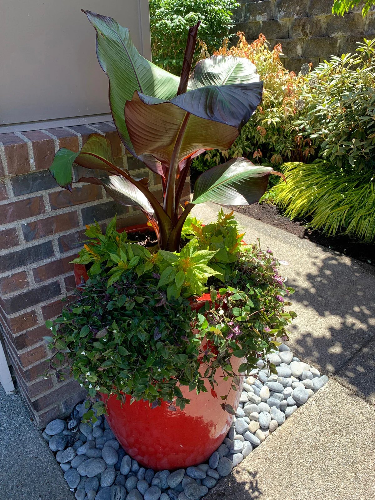 A sculptural red container accents a path beside the home.